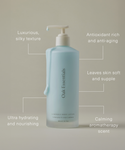 A light blue bottle of Luminous Body Lotion with a pump, infused with rose oil for a calming scent and antioxidant-rich hydration, softening skin. Set against a neutral background.
