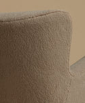 A close up image of an accent chair upholstered in textured taupe fabric with light natural wood legs, set against a solid warm beige background.