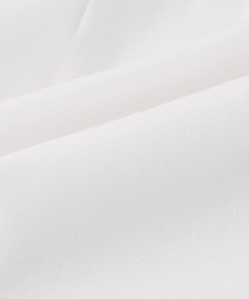 Close-up of the Blair Dress in smooth, white fabric with gentle folds, highlighting its soft linen texture and subtle shadows—perfect for upgrading your spring wardrobe.
