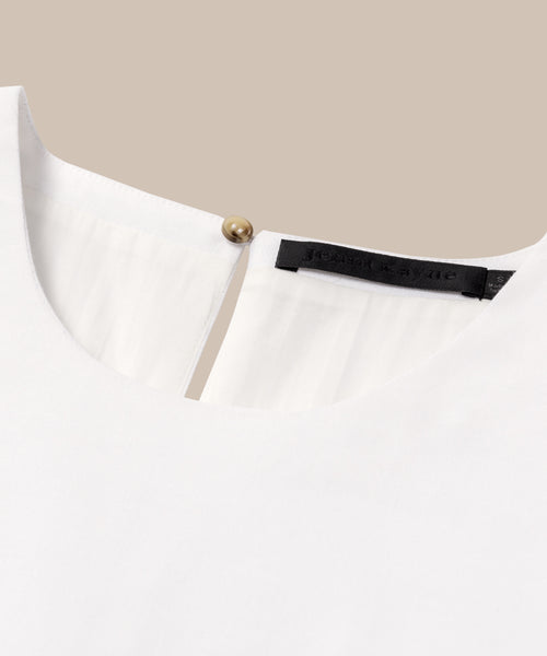 Close-up of the Blair Dresss back neckline, showing a round collar, small keyhole with a gold button, black label, and subtle linen texture—an ideal choice for your spring wardrobe.