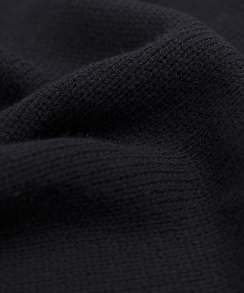Close-up of the Cameron Crewneck in black, highlighting its knitted texture and soft, wavy folds—a lightweight sweater designed for comfort and a cozy feel.