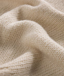 Close-up of the Cameron Crewneck, featuring soft cream-colored knit fabric with detailed texture, gentle folds, and a cozy, lightweight feel.