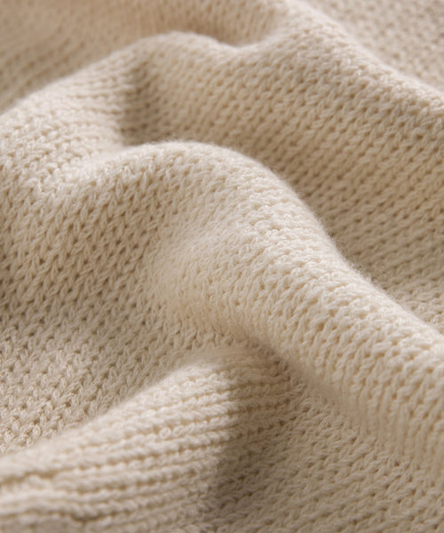 Close-up of the Cameron Crewneck, featuring soft cream-colored knit fabric with detailed texture, gentle folds, and a cozy, lightweight feel.