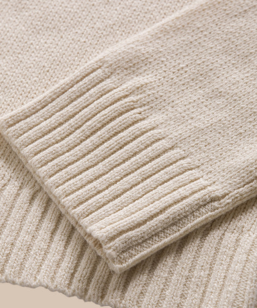 Close-up of the sleeve and hem of the Cameron Crewneck, showcasing its ribbed texture and soft, cozy cream-colored material.