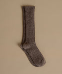 A single ribbed knit sock in a heathered taupe-brown color, displayed against a solid beige background.