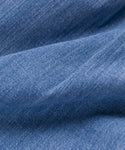 Close-up of light blue Italian denim fabric with visible texture and soft folds, highlighting the weave and color variations—ideal for spring/summer wear or pairing with the Denim Newport Trouser.