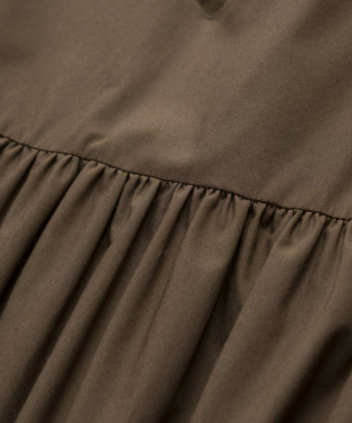 A close-up of the Cove Dress highlights its relaxed fit and subtle brown cotton texture, capturing the effortless casual style of this versatile dress.