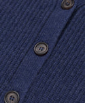 Close-up of the Cropped Cashmere Cocoon Cardigan in blue, showcasing its ribbed texture and dark buttons arranged vertically along the buttoned seam.