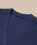 Close-up of the Cropped Cashmere Cocoon Cardigan in navy blue with a ribbed knit and V-neckline, displayed against a beige background. The inside collar shows an unreadable clothing label.