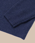 Close-up of the ribbed cuff and hem of the Cropped Cashmere Cocoon Cardigan in navy blue, shown on a beige background.