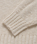 Close-up of the Cruise Cocoon Crewneck, featuring its cream color, textured knit pattern, and ribbed cuff on the lightweight sleeve.