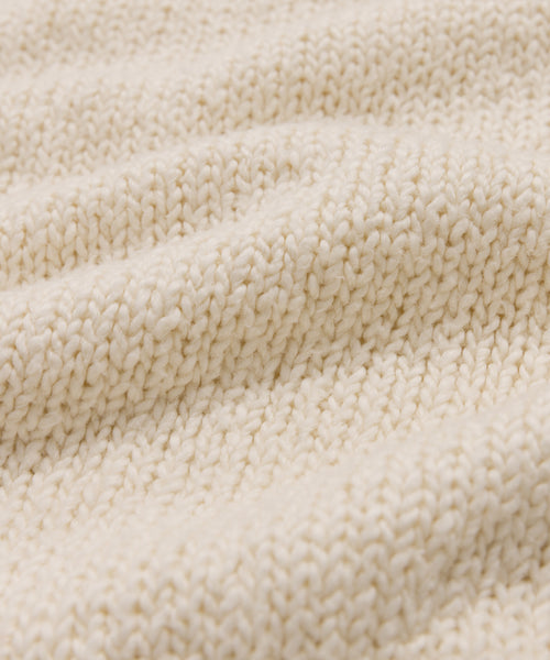 Close-up of the cream Foster Cotton Sweater, featuring a textured knit and soft, wavy folds—crafted from organic Tanguis cotton for exceptional comfort.