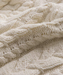 Close-up of the Cotton Cable Half Zip, showcasing its cream color, soft and thick cable knit pattern, and intricate detailing.