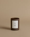 A glass candle by Jenni Kayne in the scent Malibu against a beige background.