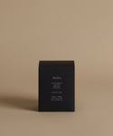 A candle box with the scent Malibu across the front against a beige background.
