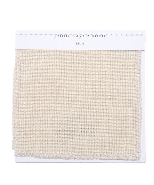 A square Fabric Swatch Pearl Linen in woven beige, labeled Jenn Kayne Home and Pearl at the top, is displayed on a white card with stitching detail along the upper edge.