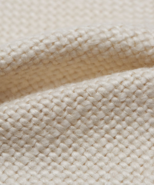Close-up of the Miramar Chair Slipcover fabric in elegant Pearl Linen—a cream-colored, basket weave textile with textured pattern and visible fibers.