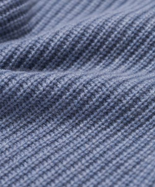 Close-up of soft, blue ribbed fabric with gentle folds, highlighting the fine stitching and cozy quality of the Kids Cashmere Fisherman sweater crafted from luxurious Mongolian cashmere.