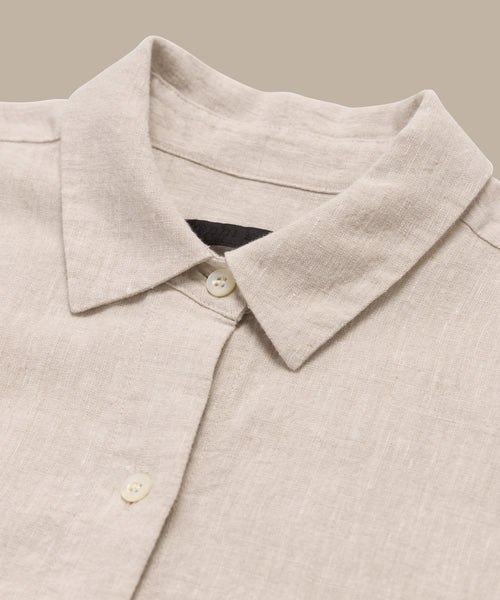 A close-up of the Linen Colby Shirt, this summer piece has a pointed collar and two cream buttons, showcased on a neutral background.