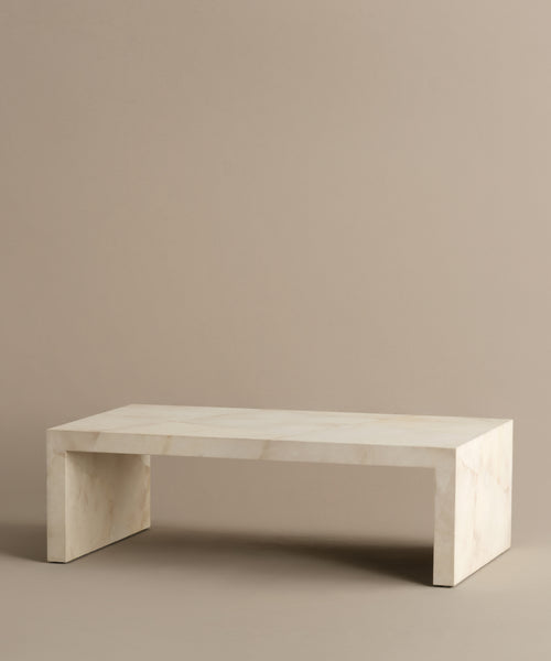 The Napa Coffee Table is a rectangular, minimalist piece crafted from light-colored marble with clean lines, shown against a plain beige background.
