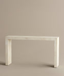 The Napa Console Table features a minimalist rectangular design with clean lines, crafted from smooth, light beige stone and displayed against a plain beige background.
