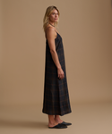 Woman wearing a plaid dress against a beige studio background.