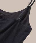 Close-up of the Rove Dress top, a black sleeveless spring-summer dress with thin adjustable straps, textured fabric, and smooth lining, set against a beige background.