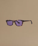 Tortoise sunglasses against a beige background.