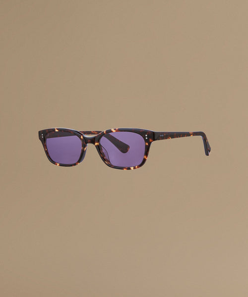 Tortoise sunglasses against a beige background.