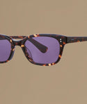Tortoise sunglasses against a beige background.