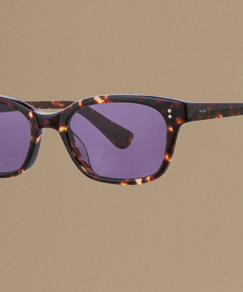 Tortoise sunglasses against a beige background.