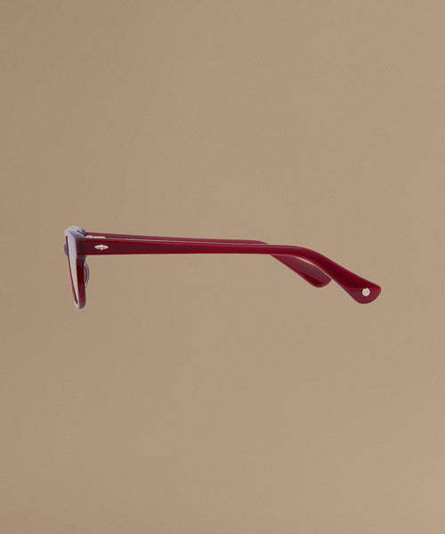 Red sunglasses against a beige background.