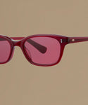 Red sunglasses against a beige background.