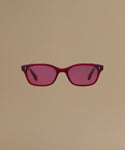 Red sunglasses against a beige background.