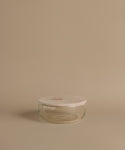 Glass canisters against a beige background.