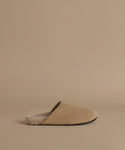A single beige slip-on mule clog with a soft textured lining, shown in profile against a solid beige background.