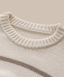 Close-up of the Chloe Crewneck’s neckline, featuring cream-colored Peruvian cotton with a ribbed collar and a subtle horizontal brown stripe across the chest, set against a beige background.