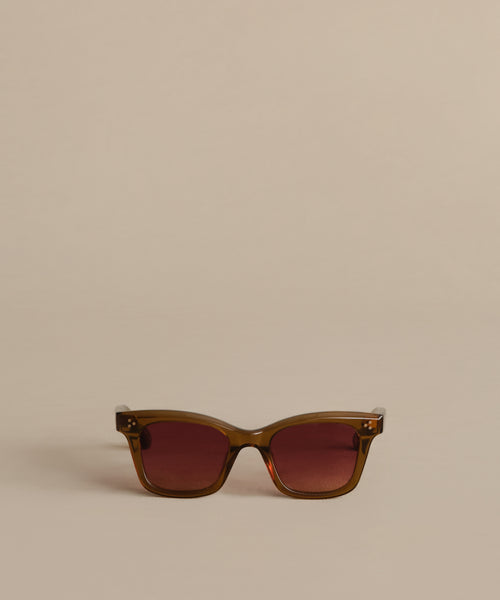 A pair of Thompson Sunglasses with brown frames and dark tinted lenses sits centered on a beige background, showcasing timeless style and dependable UV protection.
