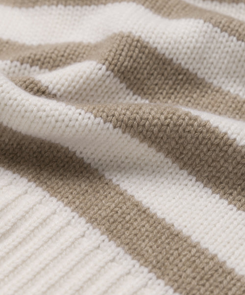 Close-up of the Cashmere Phoebe Polo, made from jersey-knit cashmere with beige and ivory horizontal stripes, highlighting its soft, textured surface and gentle folds.