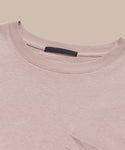 Close-up of the Vintage Pocket Tee in light pink, featuring a chest pocket and black collar label, laid flat on a beige background—ideal for everyday wear.
