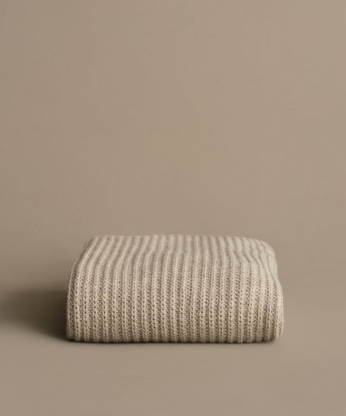 A Wool Fisherman Throw made from Andean Highland wool rests folded on a surface.