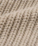 Close-up of the Wool Fisherman Throw, showcasing its beige chunky ribbed knit in soft Andean Highland wool. Thick, raised rows emphasize the cozy warmth of this Peruvian-made throw.