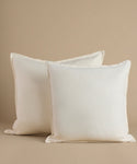 White square pillows against a beige background.