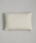 The Alpaca Basketweave Lumbar Pillow, rectangular and white with a soft woven texture, rests on a light gray surface, casting a slight shadow to the left.