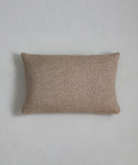 An Alpaca Basketweave Lumbar Pillow with a rectangular, textured beige design rests on a light gray, subtly textured surface, captured from above.
