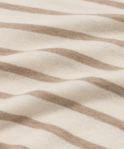 Close-up of the Avery Crewneck, a lightweight knit with beige and white horizontal stripes. The soft cotton-merino fabric features gentle folds and a smooth, flexible texture.