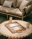 Backgammon set on a round table with a couch in the background
