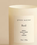 The Basil Glass Candle is a 10oz beige candle in a frosted jar labeled jenni kayne, hand-poured in Los Angeles with scent notes of neroli, green herbs, bay, and jasmine. Featured on Oprah’s Favorite Things.