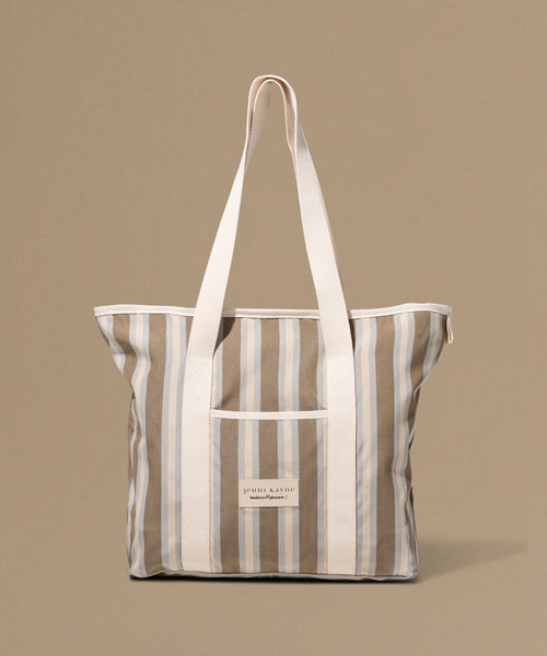 Striped tote bag with a visible brand label on a beige background