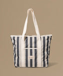 Striped tote bag with a visible brand label on a beige background